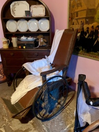 Antieke rolstoel in het hotel van Bill