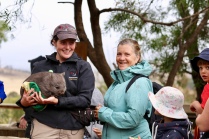 Margareth bij een verzorgster met een baby wombat